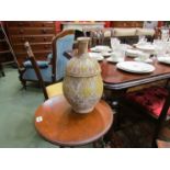 An antique hand thrown terracotta pouring vase of baluster form with narrow cylindrical neck,