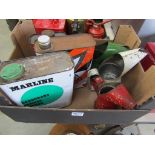 A box containing mixed oil jugs including gold cross motor oil and three oil cans