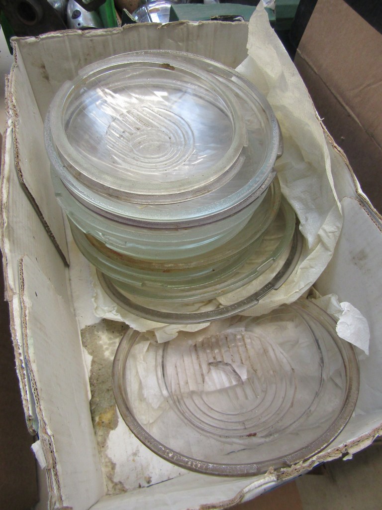 A box of assorted vintage lamp lenses