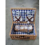 A wicker picnic basket with contents