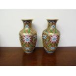 A pair of French Champleve vases with all over raised coloured enamel pattern, 17.