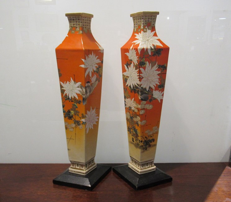 A pair of 19th Century Oriental orange and hand painted rhombus form vases with wooden bases,