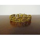 A gold handmade bracelet the panel as leaves and berries