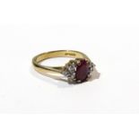 A ruby and diamond dress ring the central oval ruby flanked by three diamonds