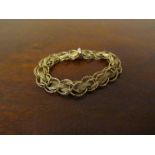 A gold fancy link bracelet twisted hoop links with fine chain and engraved loops