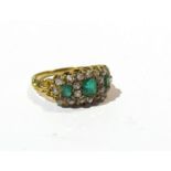 A gold emerald and diamond cluster ring, the three emeralds framed by diamonds,