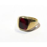 A 9ct gold gents ring set with red stone in closed back