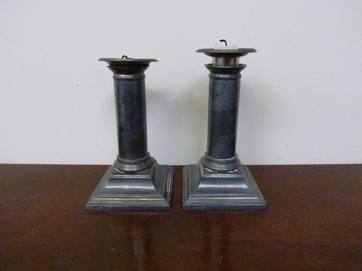 A pair of silver candlesticks with beaded detail,