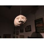 A papier mache man in the moon oversized Christmas bauble