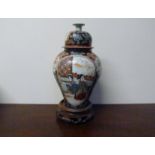A late 19th Century Japanese vase, character marks to base with wooden stand,