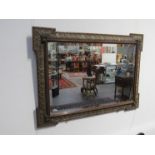 An ornate mirror with bevelled glass, retailers label verso, W. Rosenberg & Co.