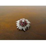 A diamond and ruby floral encrusted brooch the centre diamond .25ct approx.