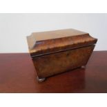 A 19th Century walnut sarcophagus form sewing box on bun feet, some veneer missing to edge.