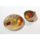 A Royal Worcester miniature cup and saucer, gilded exterior with hand painted fruit design,