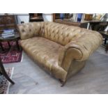 A Victorian leather button back sofa, distressed,