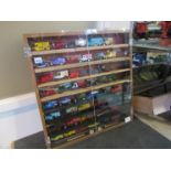 A display cabinet containing mixed diecast models including Corgi Juniors