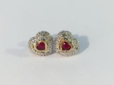 A pair of heart shaped ruby and diamond earrings