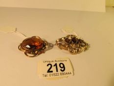2 Victorian brooches both set with amber coloured stones and with safety chains