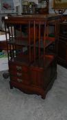 A tall Edwardian revolving bookcase with drawers and cupboard