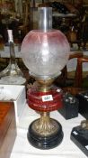 A Victorian ruby oil lamp with cranberry glass vessel & etched shade,