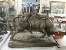 A large 20th century bronze bull with semi nude female reclining across the top,