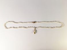 A pearl necklace with diamond set gold clasp and gold mounted drop pendant