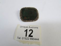 A Victorian brooch set with bloodstone in chased gold setting