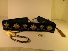 A velvet belt decorated with gold and silver coloured thread inset with precious stones