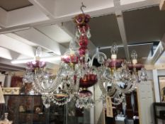 A 10 arm glass chandelier with ruby embellishments and crystal droppers