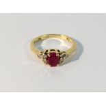 An 18ct gold claw set ring with oval ruby and diamond set shoulders,