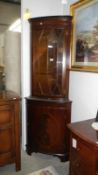 A mahogany modern corner cupboard