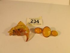 A yellow amber vintage brooch set with three amber ovals and an amber brooch fashioned as a carp