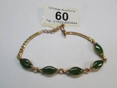 A yellow metal and jade bracelet