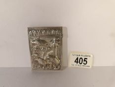 An unmarked white metal card case depicting native scene with animals,