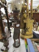 A tall carved wood African figure with feathers for hair