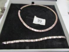 A silver necklace with matching bracelet