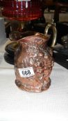 A 19th century embossed copper jug with brass seams