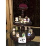 16 porcelain collector's thimbles on stand