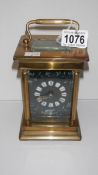 A large brass carriage clock with enamel face