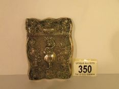 An unmarked white metal card case depicting a dancer, 9 x 6.