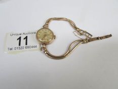 A ladies Accurist gold watch and bracelet,