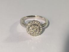 A circular white gold half carat diamond ring,