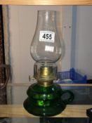 A green glass hand oil lamp with chimney