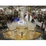 A Victorian decanter and 6 glasses of gilded stand