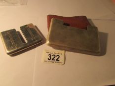 A silver card case in holder marked Sterling Ortega and an unmarked card case