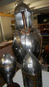 A replica English civil war helmet and breastplate with stand
