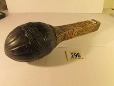 A tribal rattle with carved coconut top