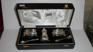 A cased white metal condiment set bearing foreign silver marks