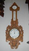 An Edwardian oak aneroid barometer with clock & porcelain faces,