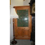 An astragal glazed pine corner cupboard